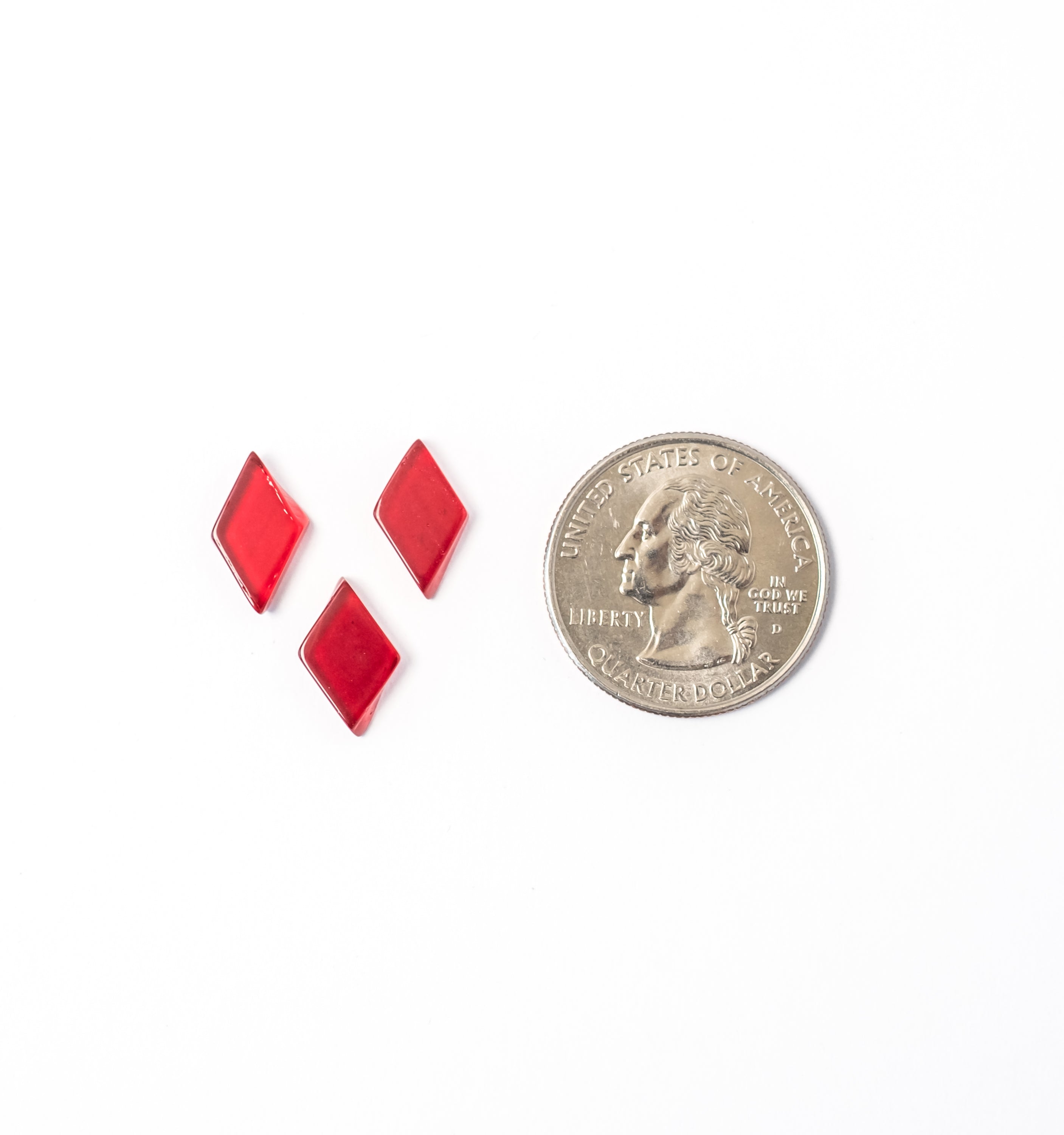 Red glass mosaic tiles of diamond shape for various craft projects.