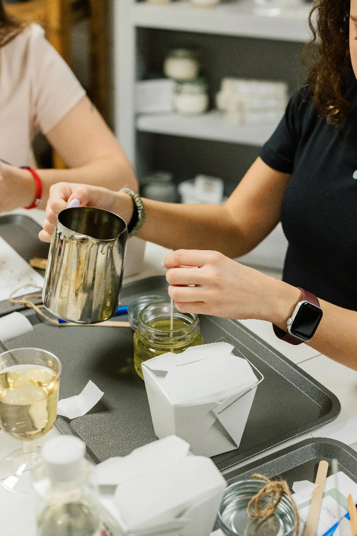 Team members measuring scents and wax for custom candle making.