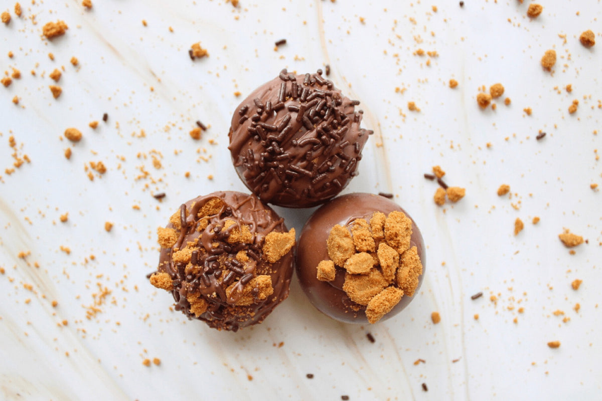 Coffee bombs grouped together with crumbled biscuit scattered around them