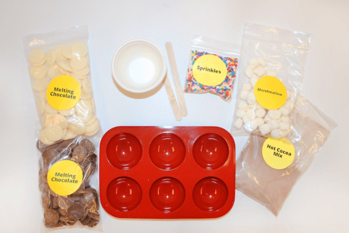 Hot chocolate bomb kit: red silicone mould, chocolate discs, marshmallows and sprinkle sachets