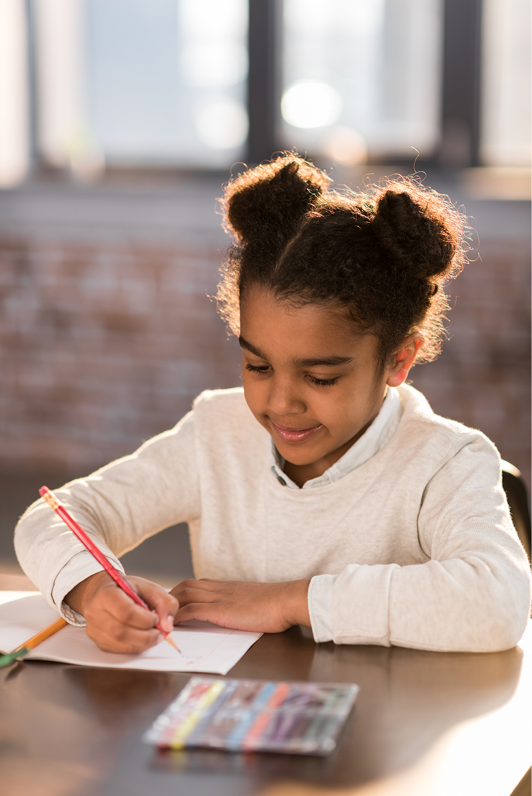 Smiling girl drawing with colored pencils