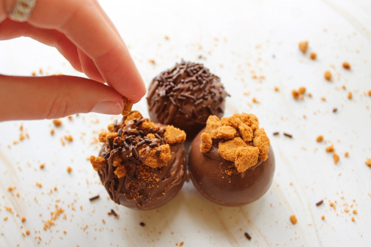 Hand sprinkling biscuit crumble over finished coffee bombs