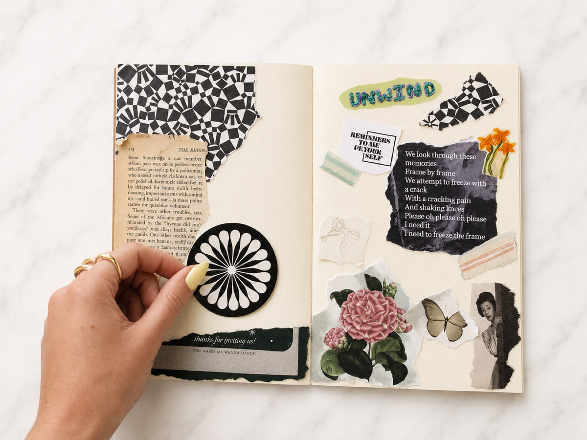 Hand placing a paper rosette onto an open journal spread