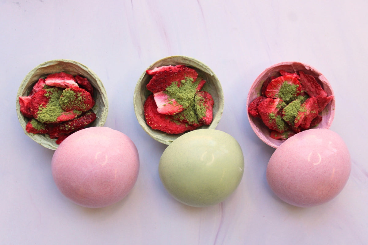 Open matcha bomb halves filled with matcha powder and freeze-dried strawberry