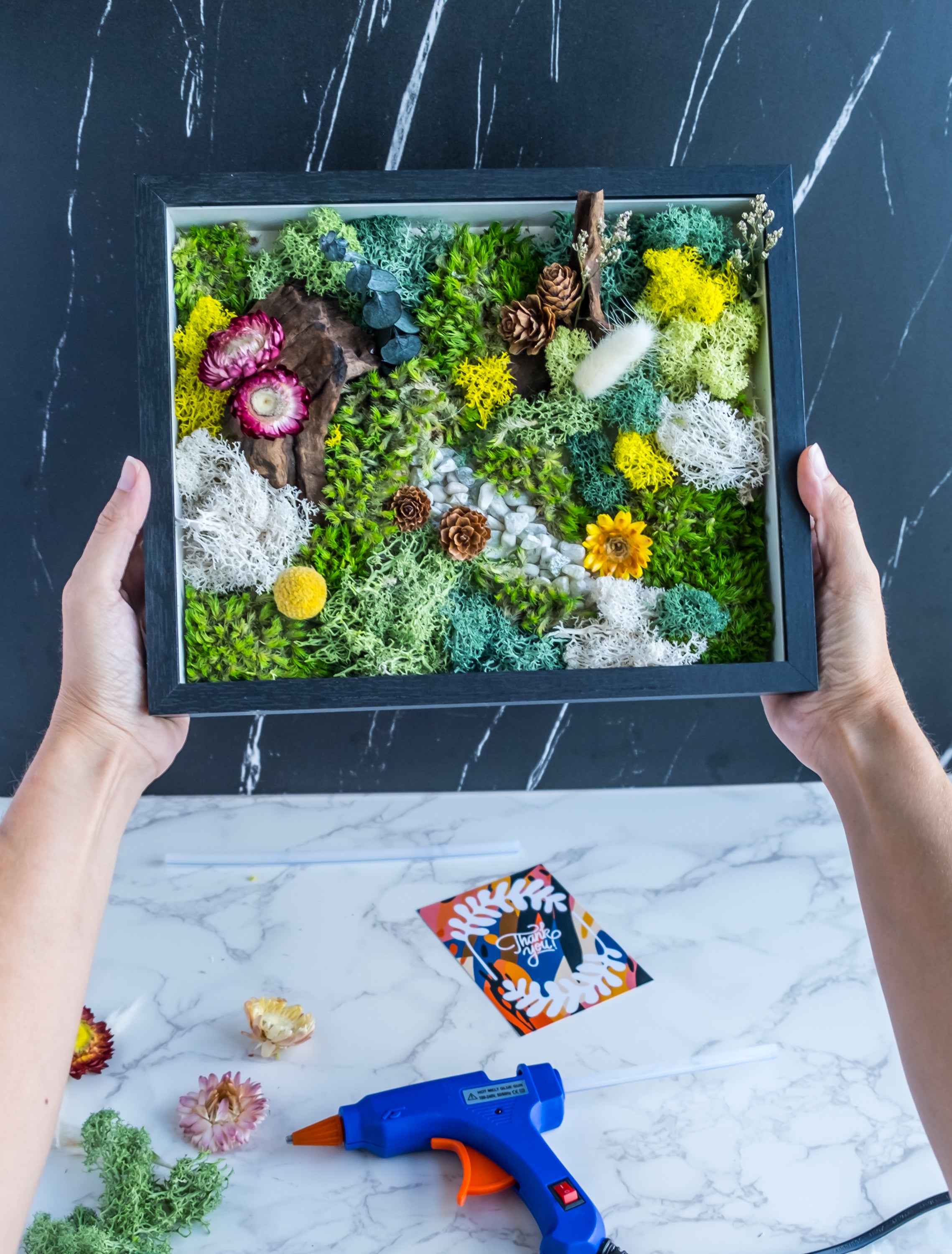 DIY Moss Wall Art Kit - A nature-inspired masterpiece with preserved moss, flowers, and other natural elements in a modern black frame.