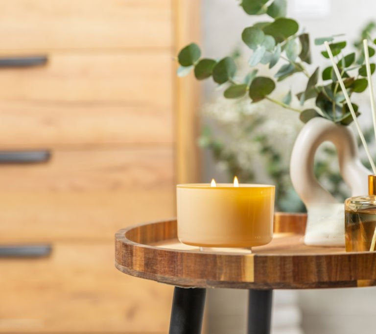 candle lit on top of the table with aroma oils