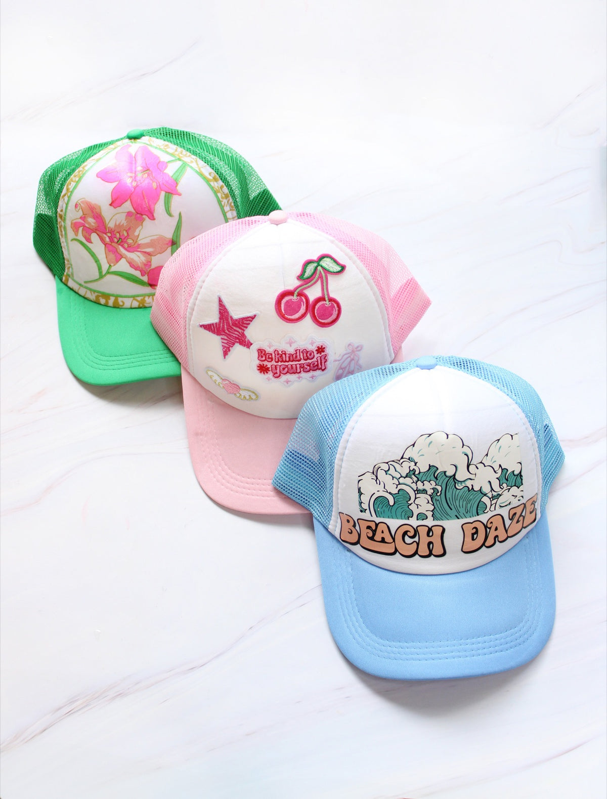 Finished trucker hats arranged on a marble surface