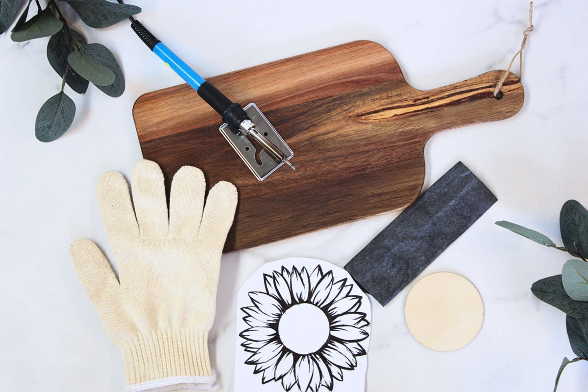 Wood burning kit: pen, wooden board, protective glove, sanding block and a sunflower stencil