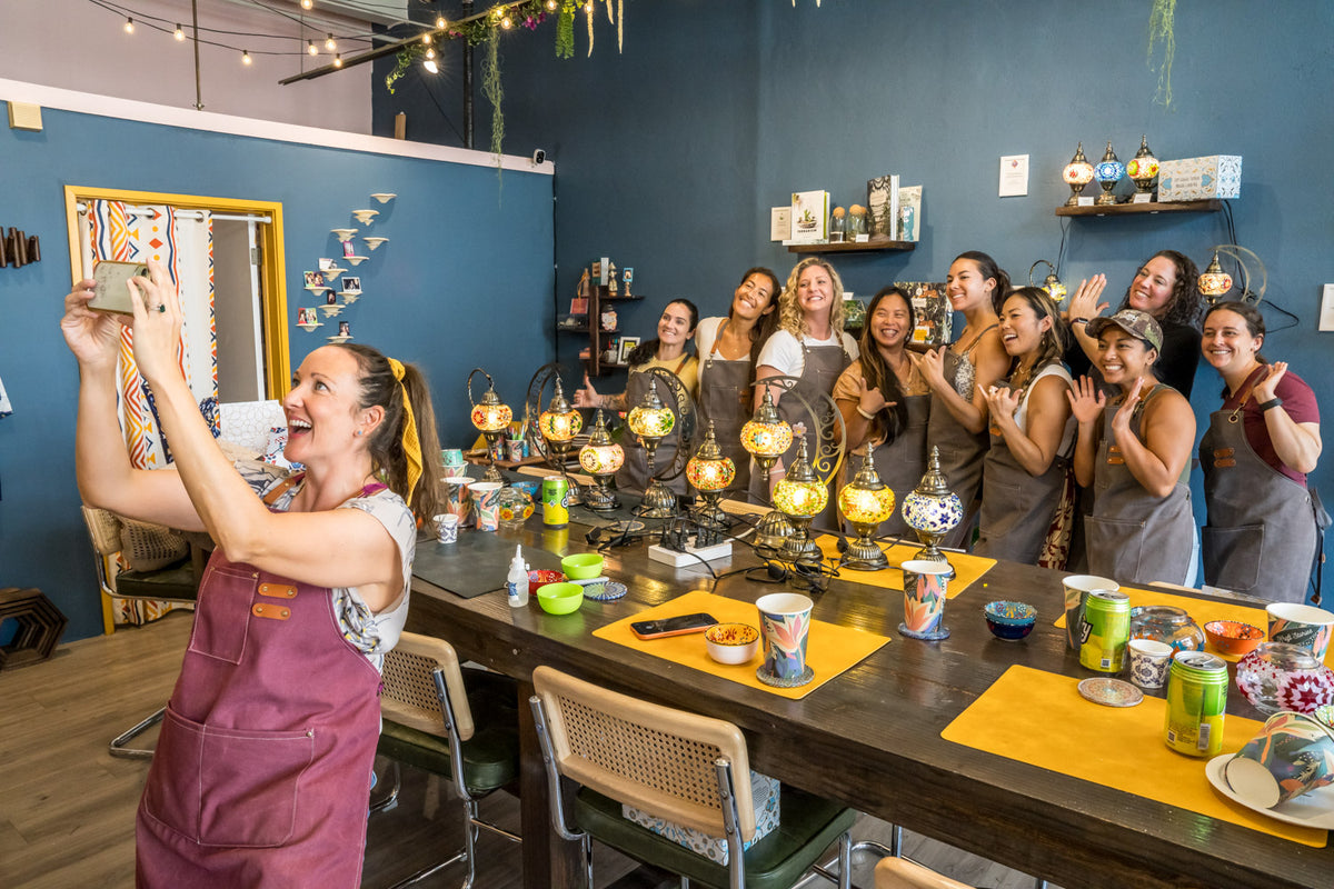 ladies taking a picture of their lamps after mosaic lamp workshop at KraftStories Hawaii